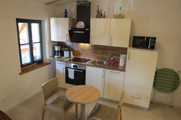 Küchenzeile FeWo am Zwenkauer See Kompakte Küchenzeile mit modernem Design, Tisch und Stühlen.