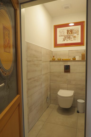 Toilette FeWo am Zwenkauer See Sauberes, modernes WC mit Fliesen und Holzdetails in einem hellen Raum.