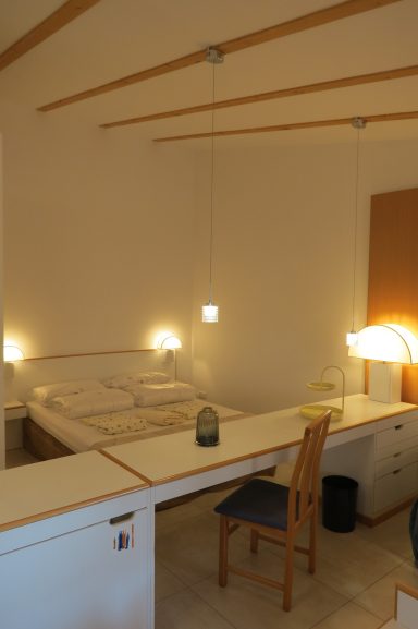Doppelbett FeWo am Zwenkauer See Helles Zimmer mit Doppelbett, Schreibtisch, Stuhl und Nachttischlampen.